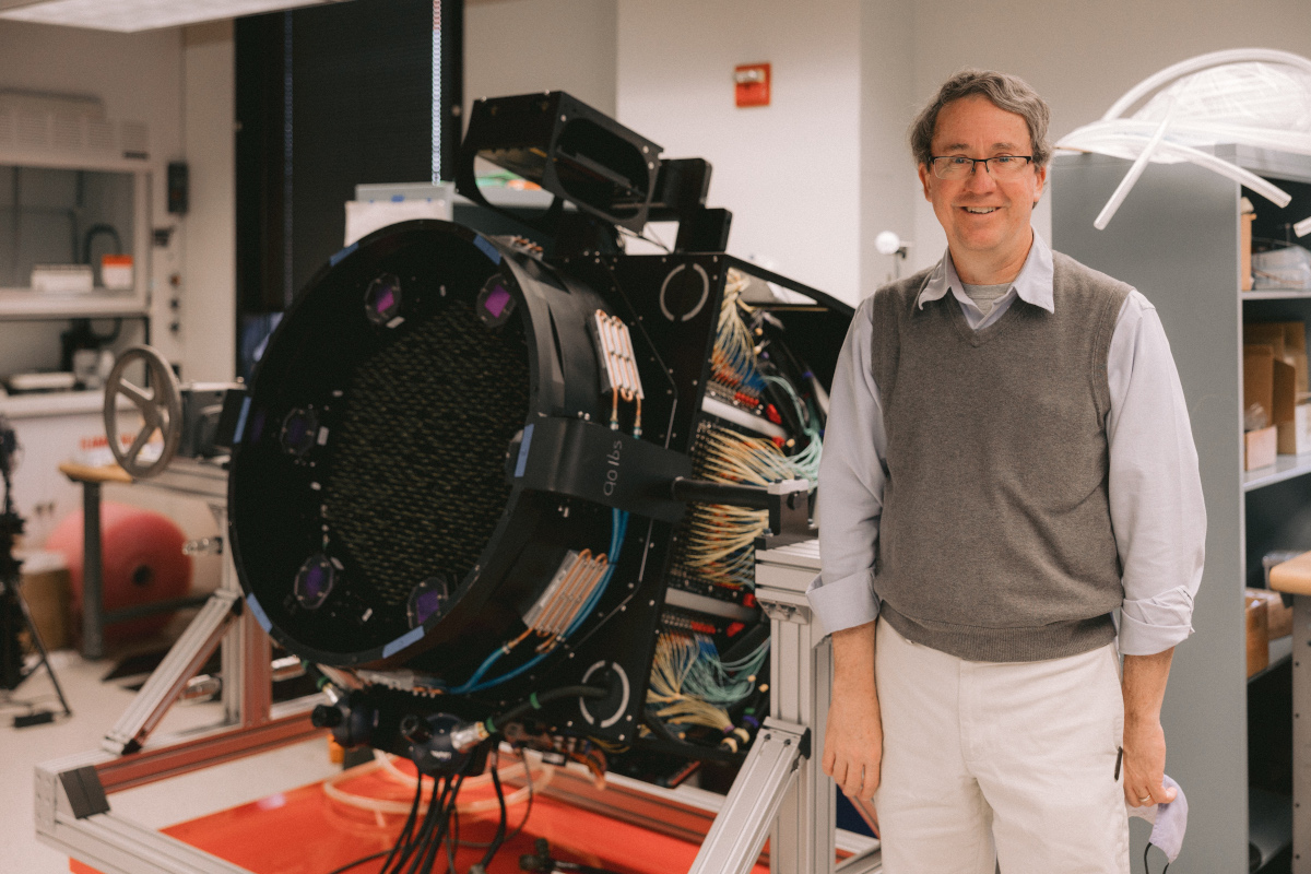 Photo Richard Pogge standing next to the Sloan Focal Plane System instrument in November 2021